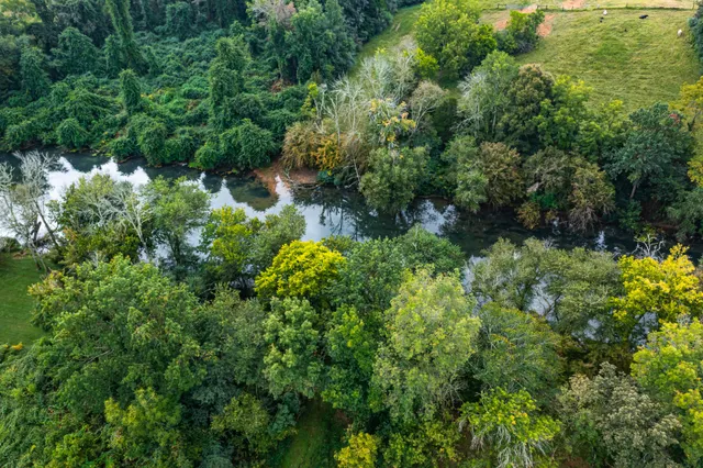an aerial view of a residential houses with outdoor space and swimming pool
