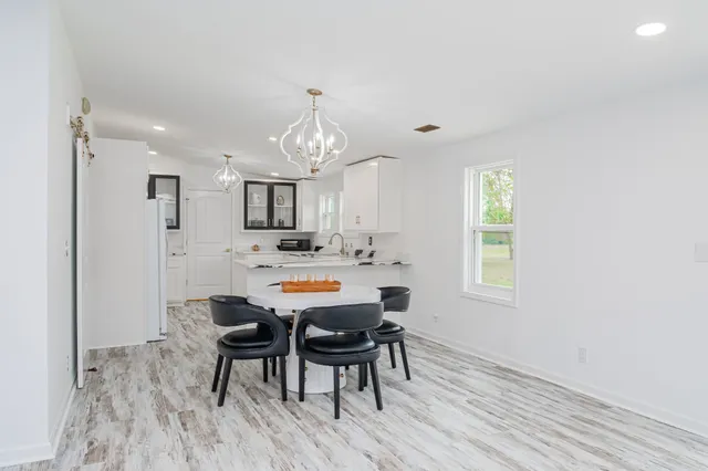 a view of a dining room with furniture and chandelier