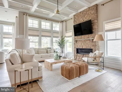 a living room with furniture a flat screen tv and a large window