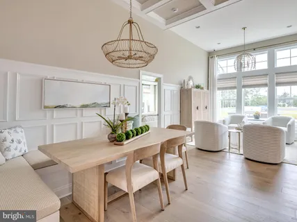 a kitchen with a center island wooden floor dining table and chairs
