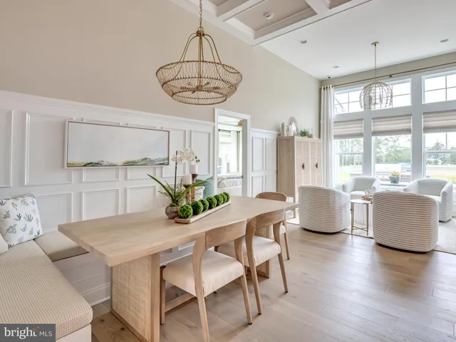 a kitchen with a center island wooden floor dining table and chairs