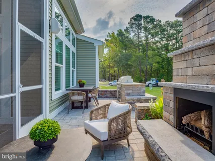 a view of a brick house with a chairs in patio