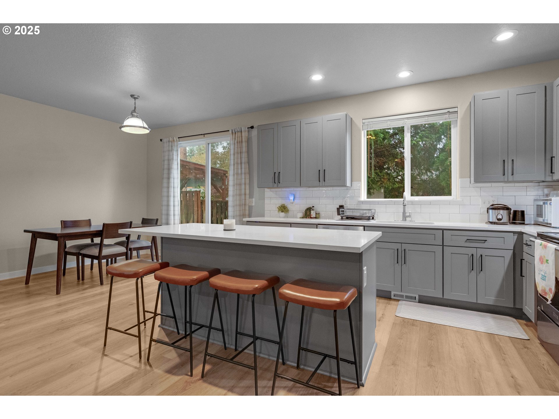 17670 Southwest September Lane Beaverton, OR 97003 - Photo 14 of 34 a kitchen with granite countertop a table chairs a sink dishwasher window and cabinets