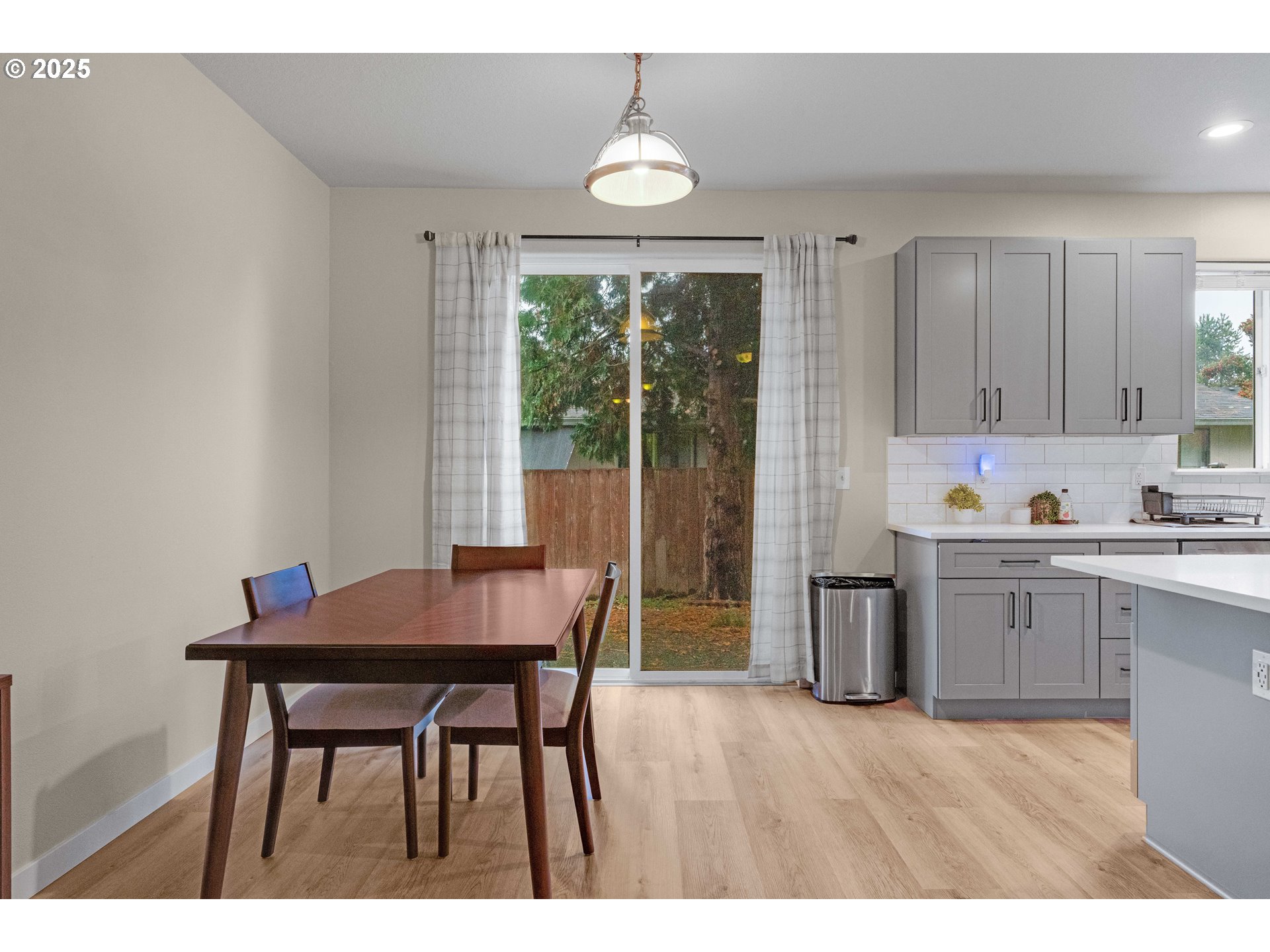 17670 Southwest September Lane Beaverton, OR 97003 - Photo 10 of 34 a open kitchen with granite countertop a dining table chairs and a refrigerator