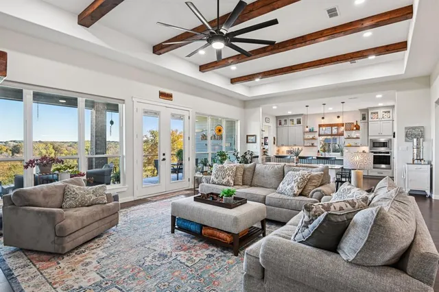 a living room with furniture kitchen view and a large window
