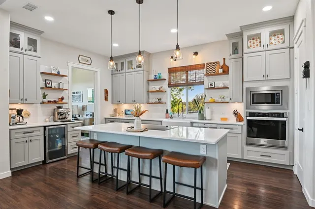 a kitchen with stainless steel appliances granite countertop a stove a kitchen island a refrigerator and a stove