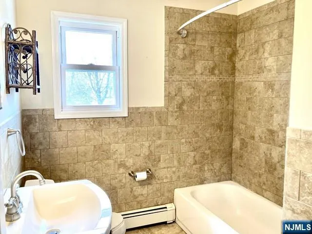 a bathroom with a sink a bathtub and a window