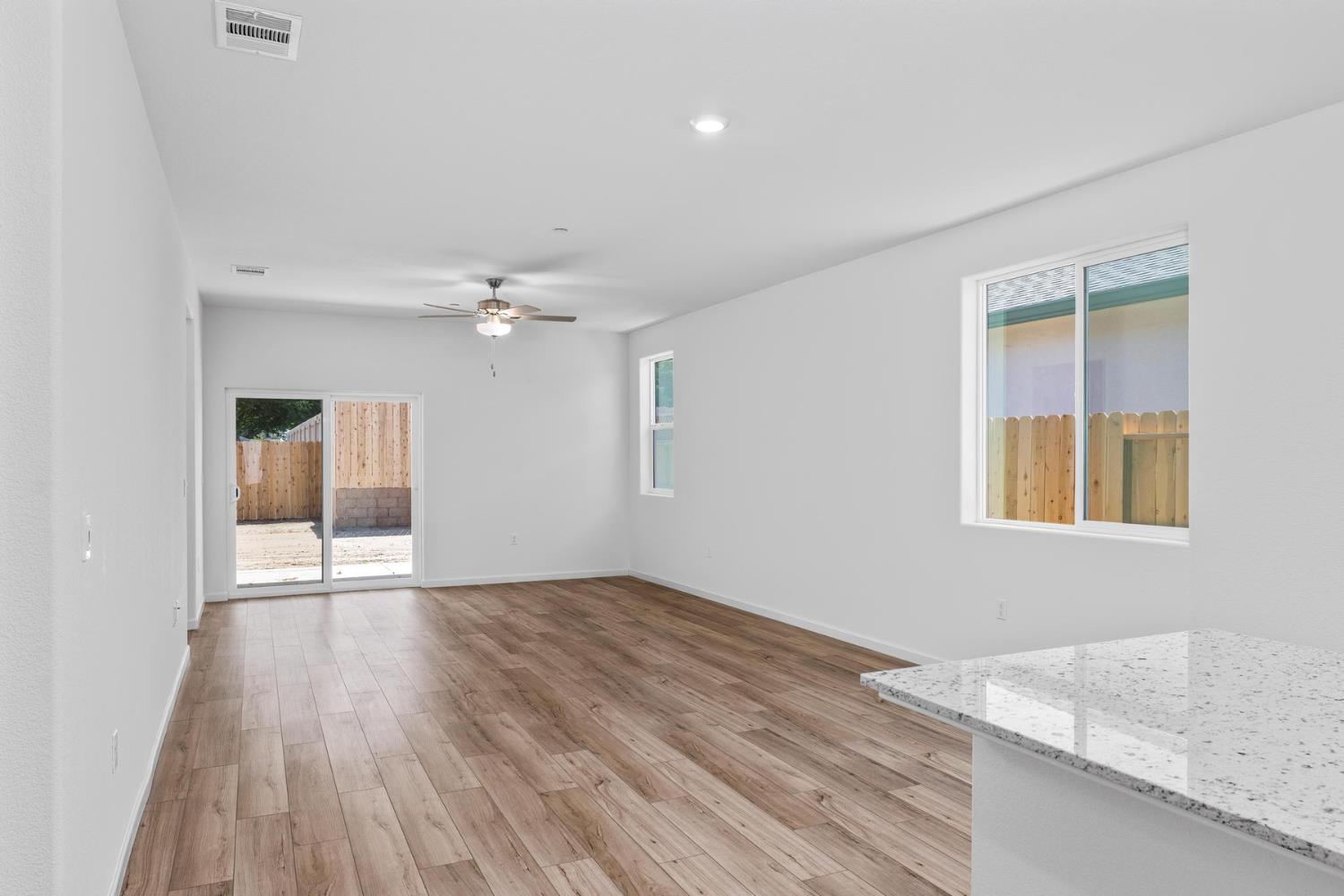 6691 Snedigar Road Riverbank, CA 95367 - Photo 3 of 12 an empty room with wooden floor cabinet and windows