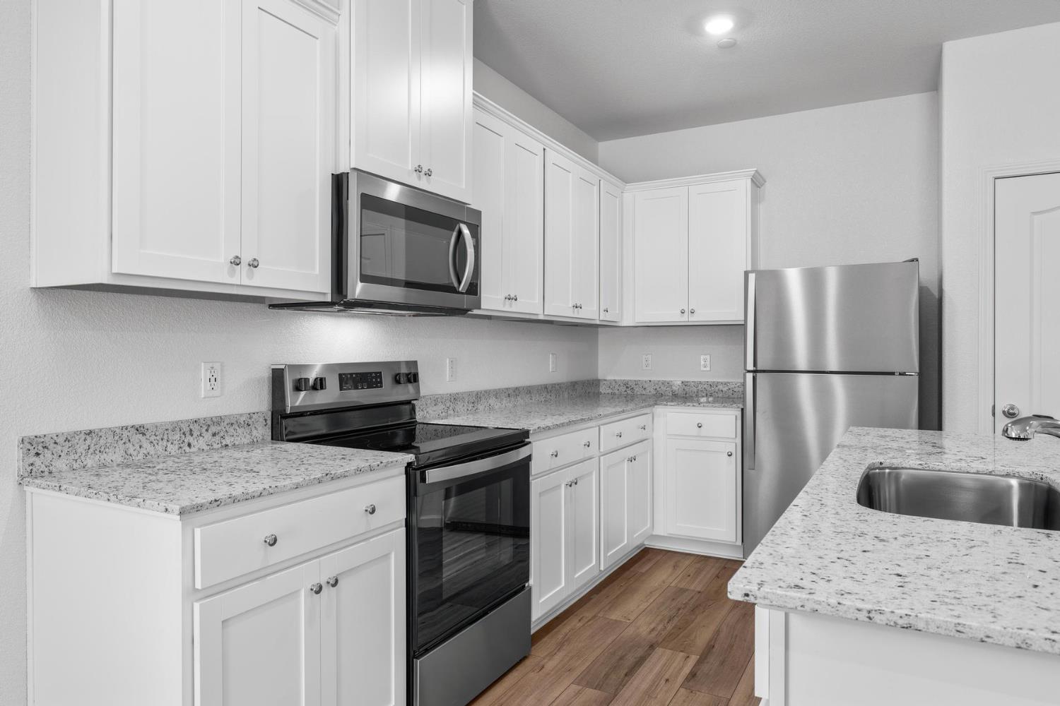 6691 Snedigar Road Riverbank, CA 95367 - Photo 7 of 12 a kitchen with granite countertop a sink stove and refrigerator