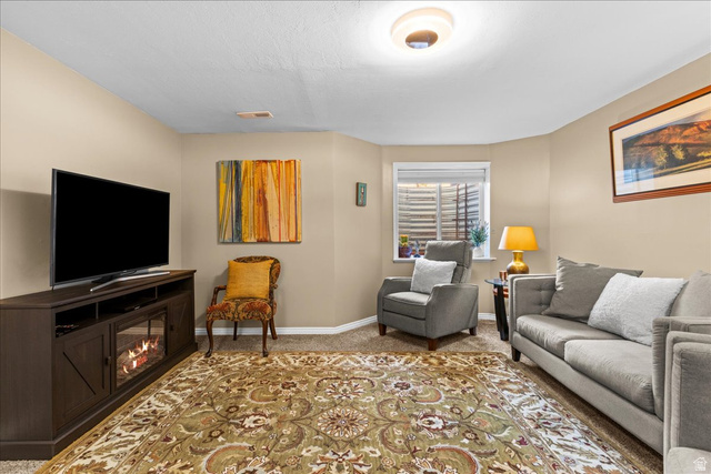 7824 South Sequoia Tree Lane Sandy, UT 84094 - Photo 31 of 43 Living room with carpet floors and a glass covered fireplace