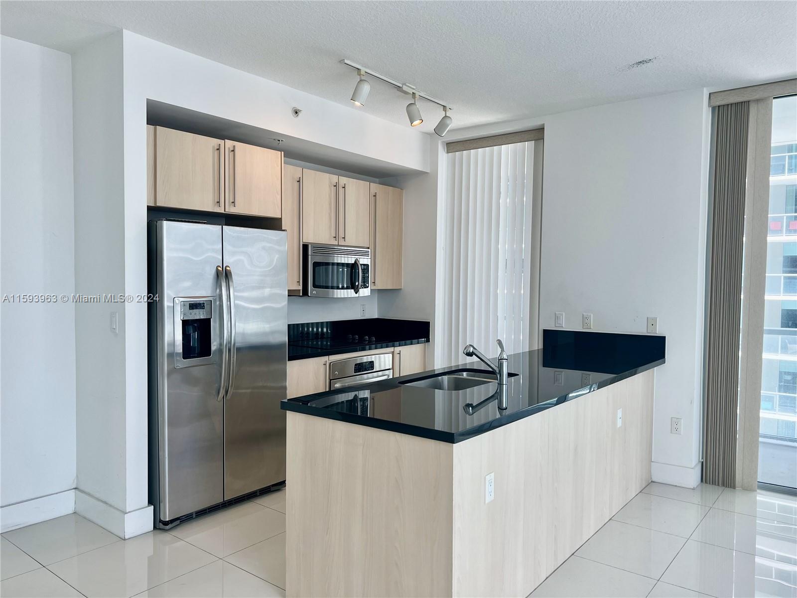 a kitchen with stainless steel appliances granite countertop a refrigerator and a sink
