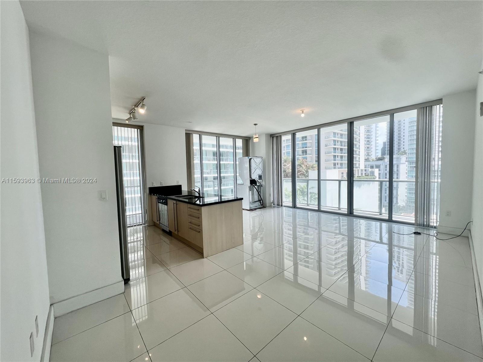 79 Southwest 12th Street, Unit 1407 Miami, FL 33130 - Photo 2 of 16 a large white room with a large window and kitchen view