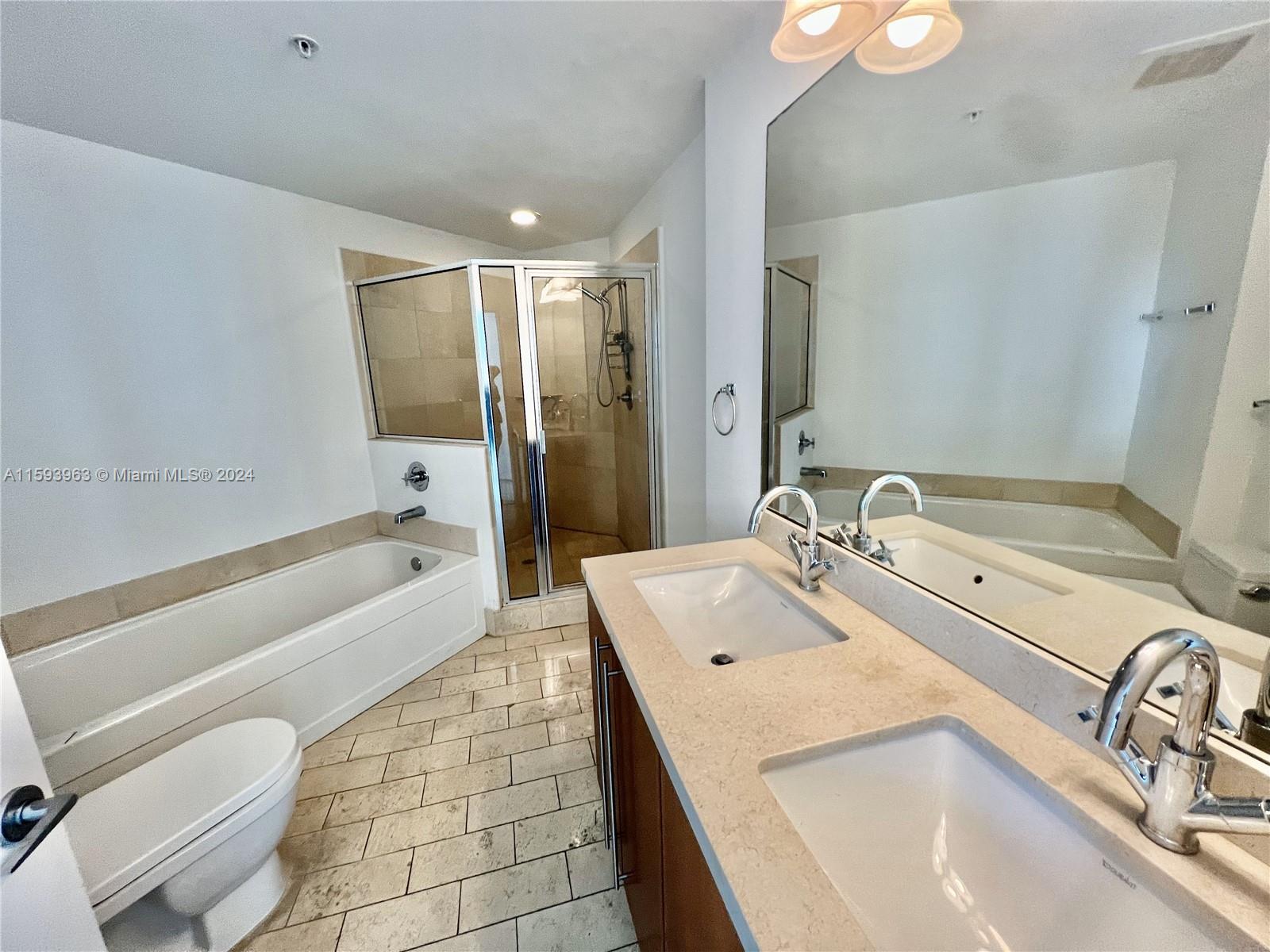 79 Southwest 12th Street, Unit 1407 Miami, FL 33130 - Photo 4 of 16 a bathroom with a sink a toilet and bathtub