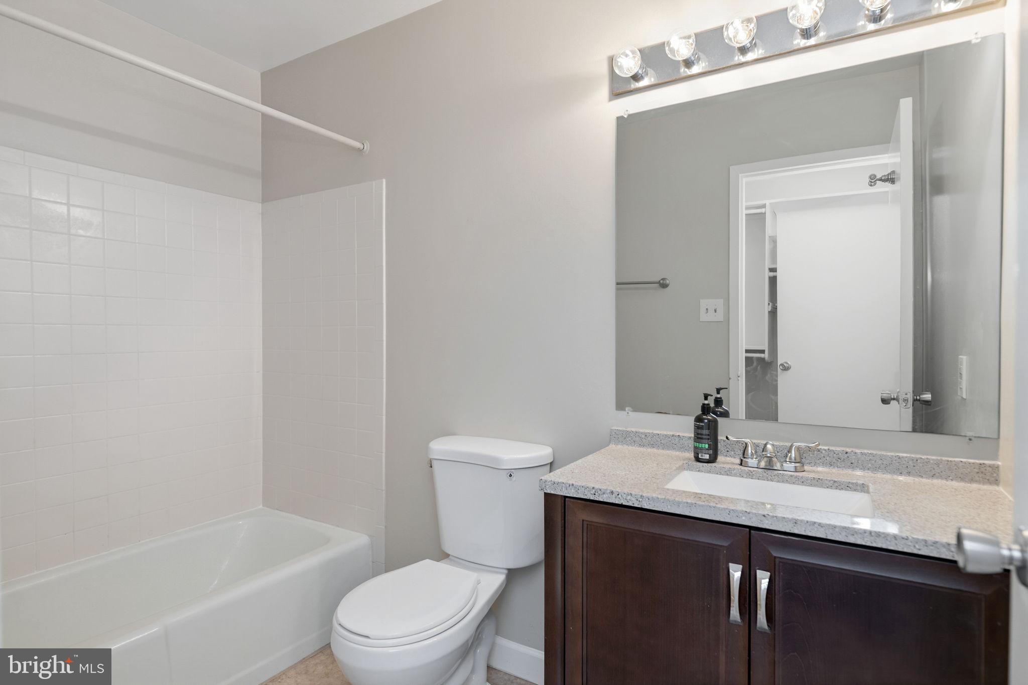 1443 Northgate Square, Unit 22B Reston, VA 20190 - Photo 22 of 42 a bathroom with a granite countertop sink toilet and shower
