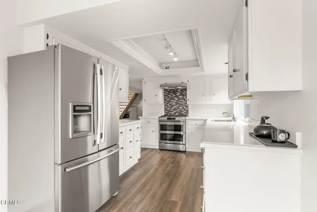 a kitchen with stainless steel appliances a refrigerator sink and cabinets