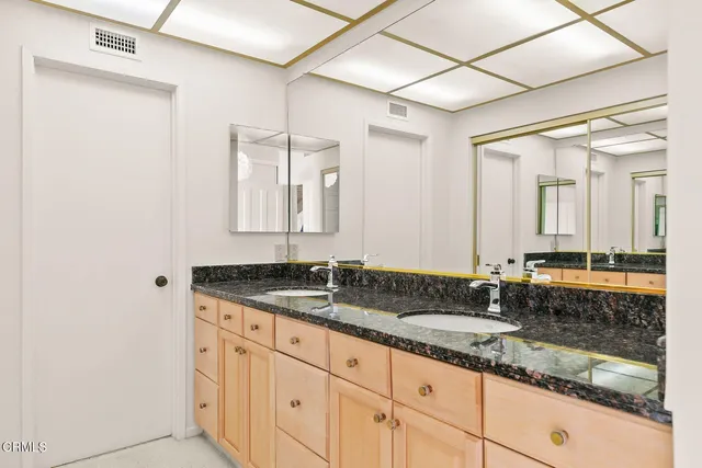 a bathroom with a granite countertop sink and a mirror