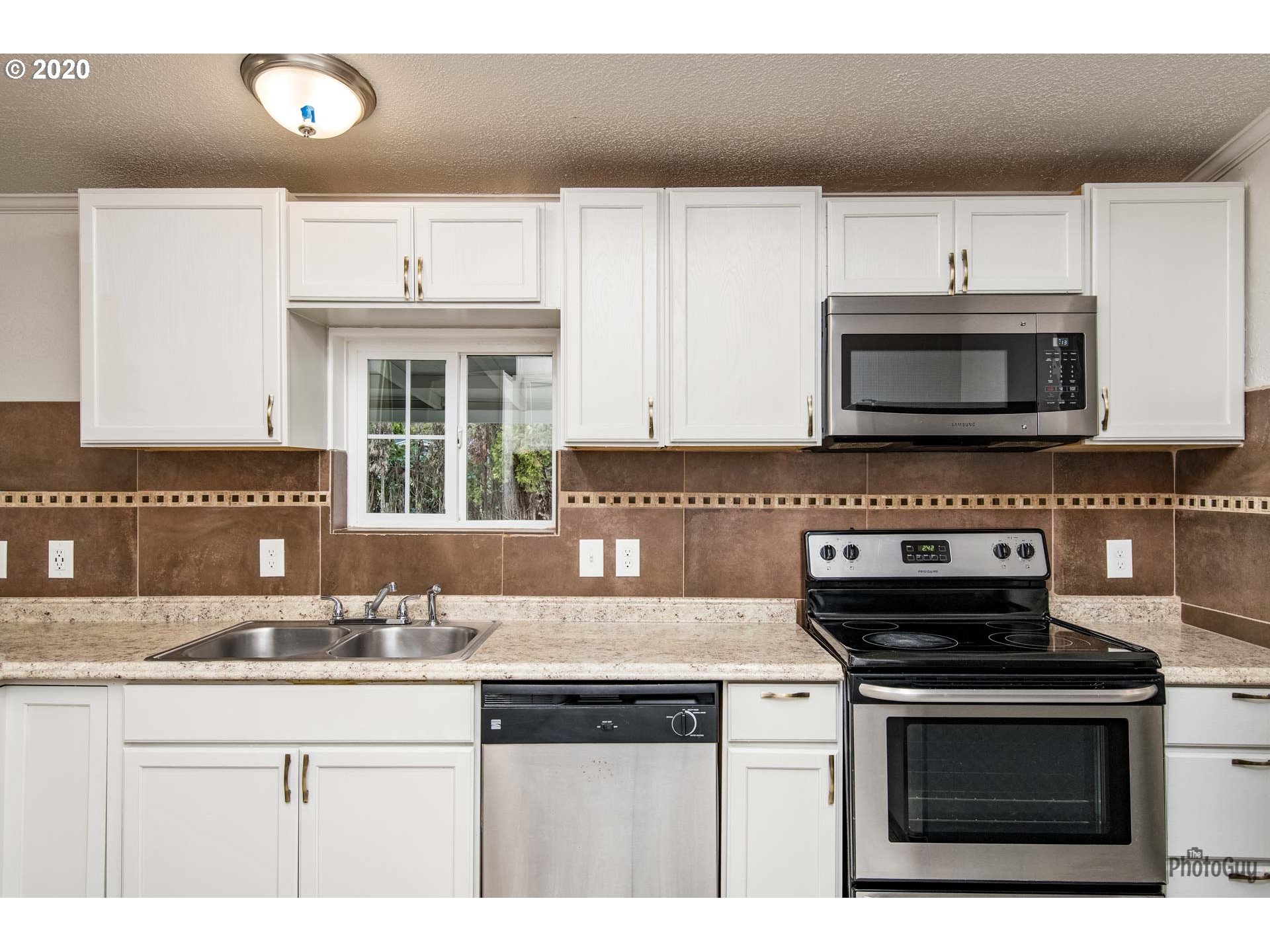 1053 South 58th Street Springfield, OR 97478 - Photo 12 of 32 a kitchen with granite countertop a stove a microwave a sink and cabinets