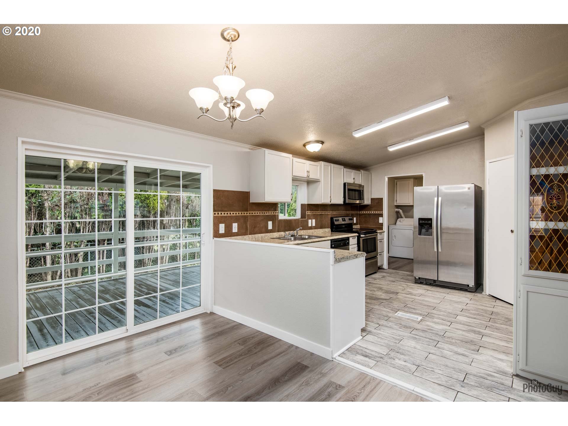 1053 South 58th Street Springfield, OR 97478 - Photo 7 of 32 a kitchen with stainless steel appliances granite countertop a refrigerator a sink dishwasher a oven with white cabinets and wooden floor