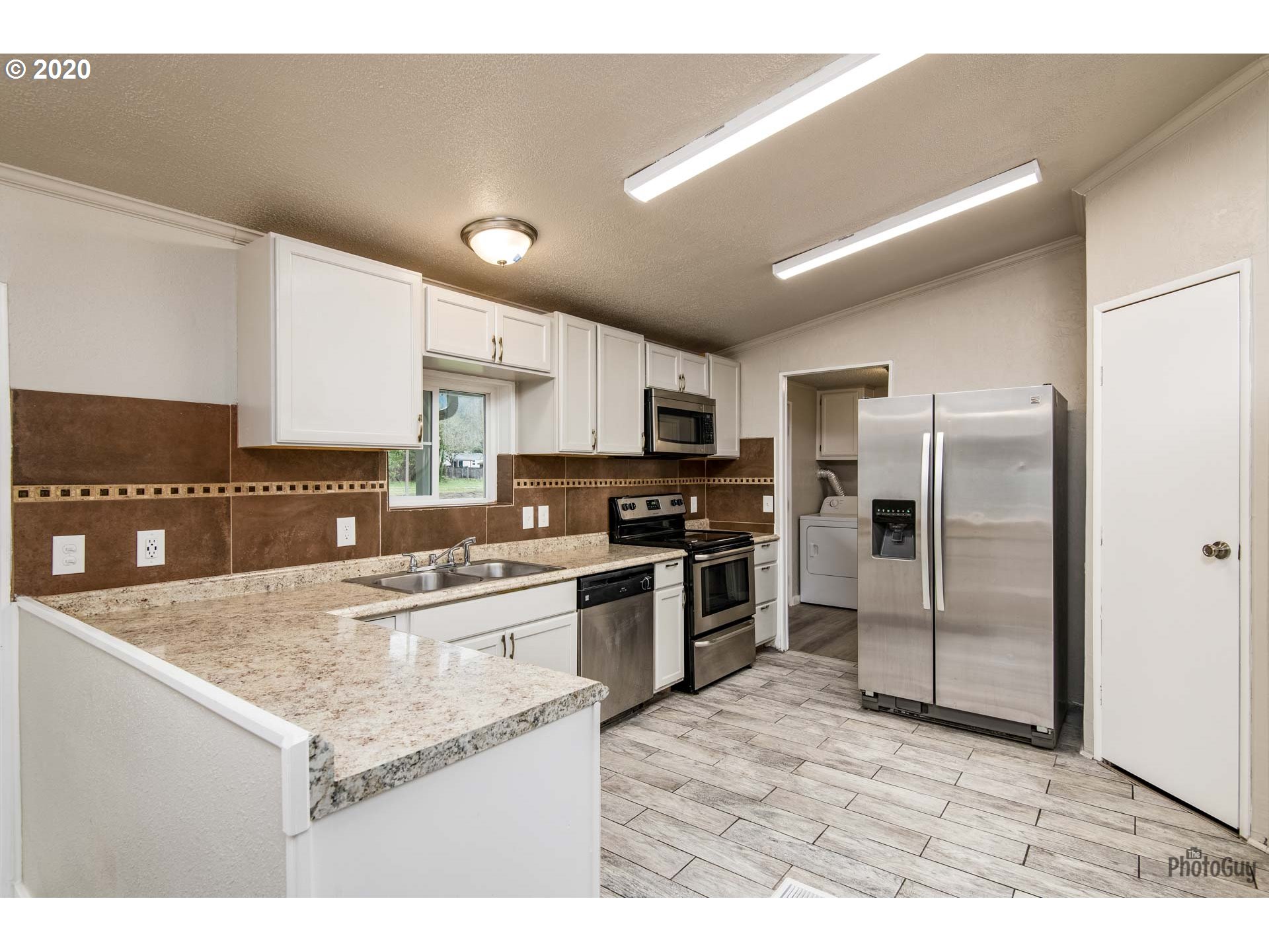 1053 South 58th Street Springfield, OR 97478 - Photo 9 of 32 a kitchen with stainless steel appliances granite countertop a refrigerator a sink a stove a microwave and island