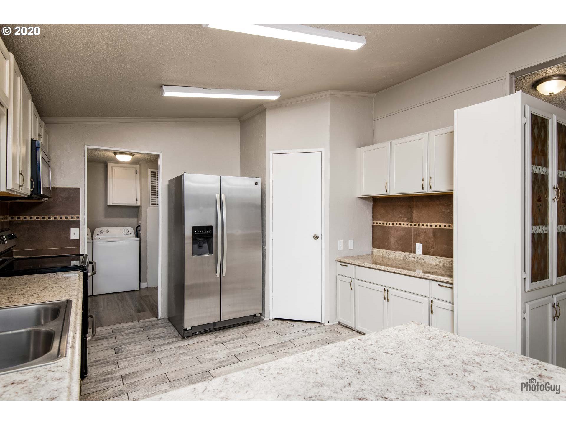 1053 South 58th Street Springfield, OR 97478 - Photo 10 of 32 a kitchen with stainless steel appliances kitchen island granite countertop a refrigerator and a sink
