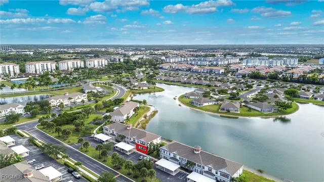 an aerial view of ocean and residential houses with outdoor space