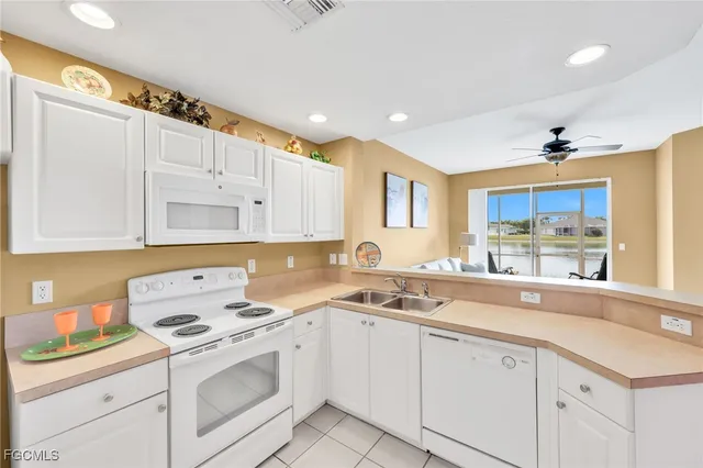 a kitchen with cabinets appliances a sink and a window
