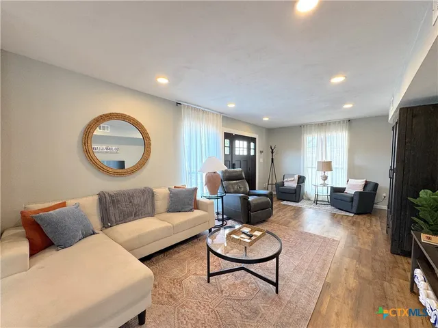 a living room with furniture and a wooden floor