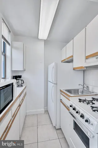 a kitchen with stainless steel appliances a white stove top oven and refrigerator