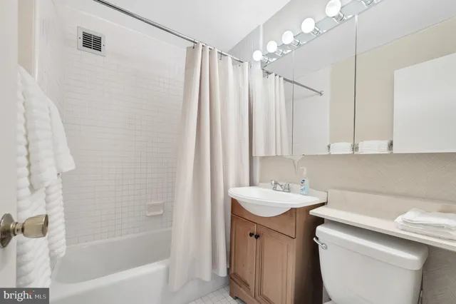 a bathroom with a sink a toilet a mirror a shower and a bathtub