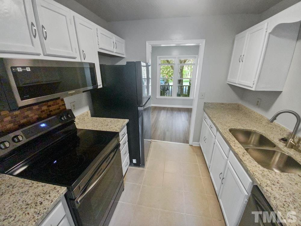 8236 Merriweather Circle Raleigh, NC 27616 - Photo 2 of 15 a kitchen with granite countertop a refrigerator stove and sink