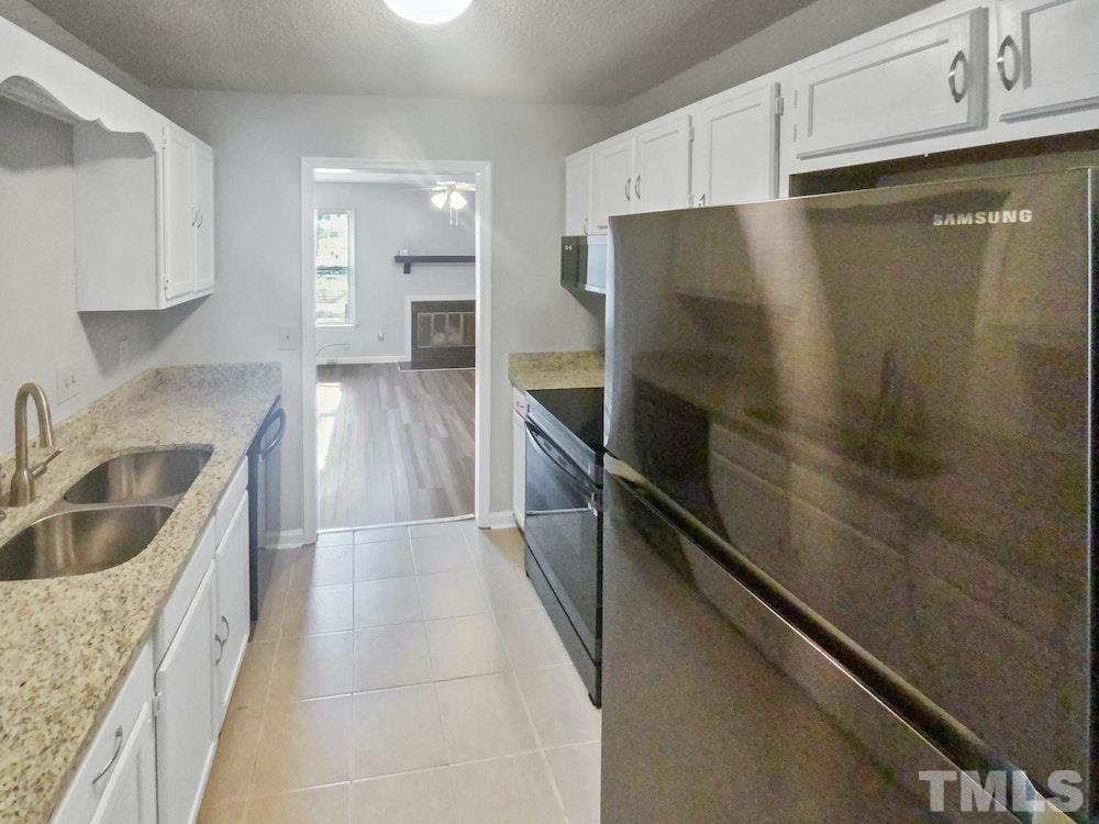 8236 Merriweather Circle Raleigh, NC 27616 - Photo 6 of 15 a kitchen with granite countertop a refrigerator and a sink