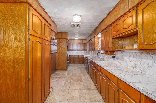 a large kitchen with stainless steel appliances granite countertop a sink and cabinets