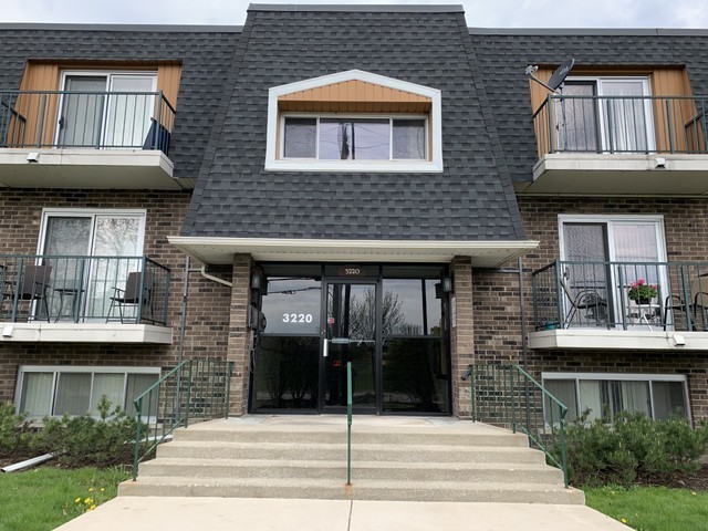 a front view of a house with glass windows and a yard