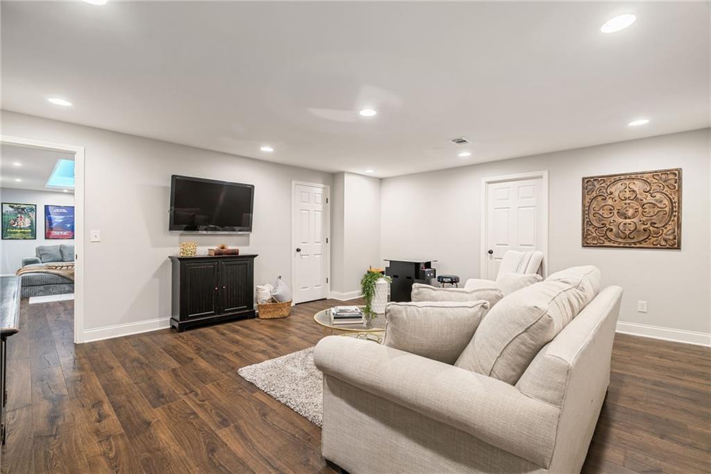 7933 Midway Road Alpharetta, GA 30004 - Photo 64 of 101 a living room with furniture a flat screen tv and kitchen view