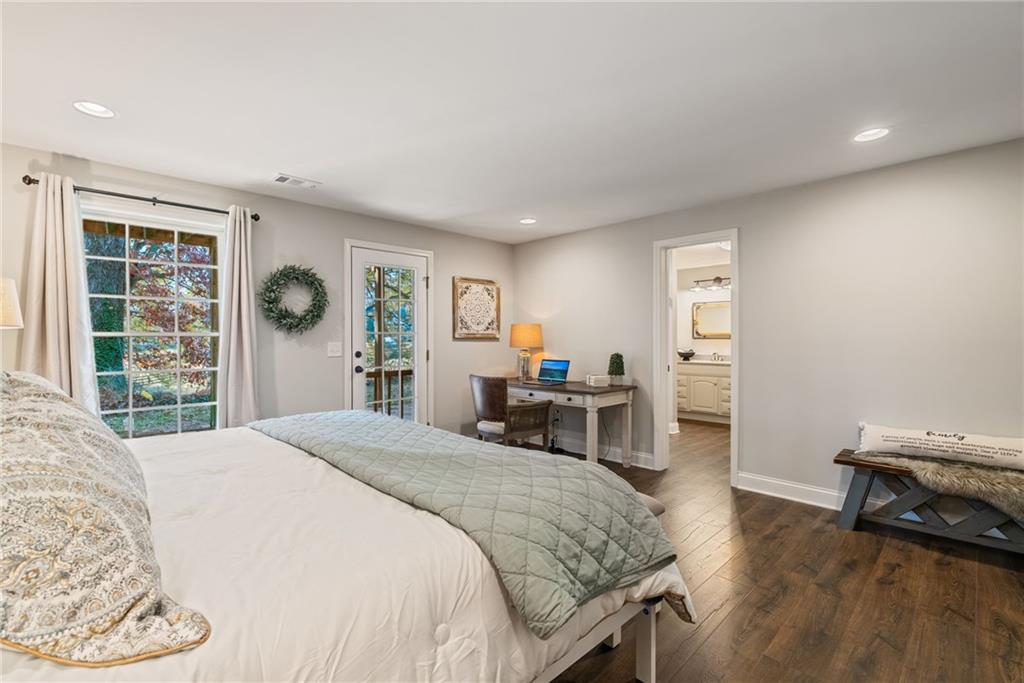 7933 Midway Road Alpharetta, GA 30004 - Photo 66 of 101 a spacious bedroom with a bed and a table in it with wooden floor