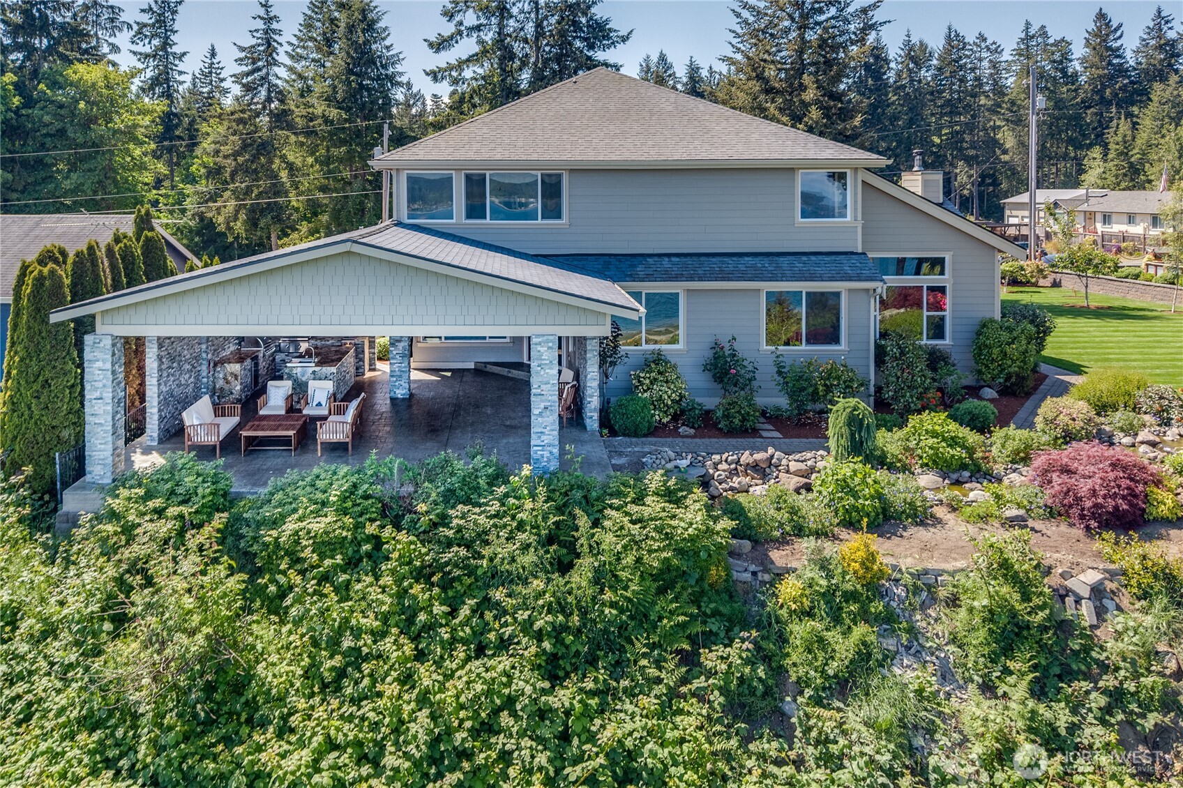 1411 Thorndyke Road Port Ludlow, WA 98365 - Photo 3 of 40 a front view of a house with a yard and potted plants