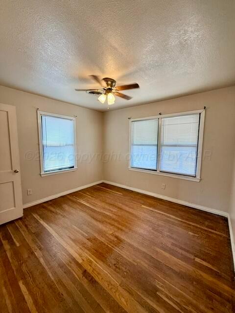 4623 Crockett Street Amarillo, TX 79110 - Photo 7 of 9 a view of an empty room with wooden floor and a ceiling fan