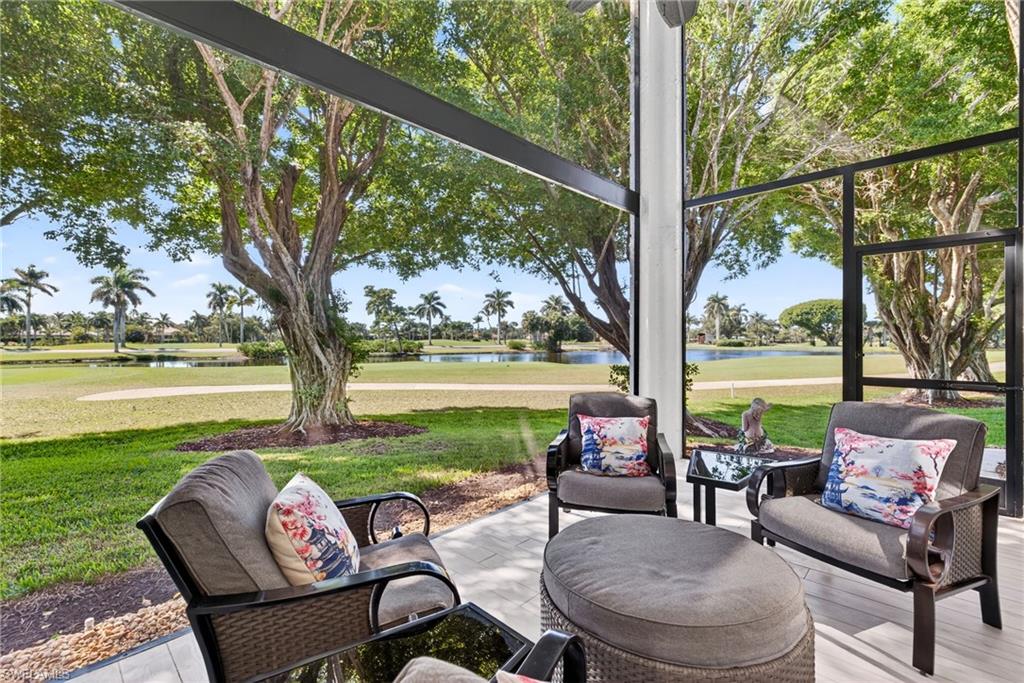 2193 Paget Circle, Unit 1 25 Naples, FL 34112 - Photo 1 of 50 a view of a patio with couches table and chairs under an umbrella