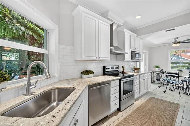 a kitchen with stainless steel appliances granite countertop a sink stove and cabinets