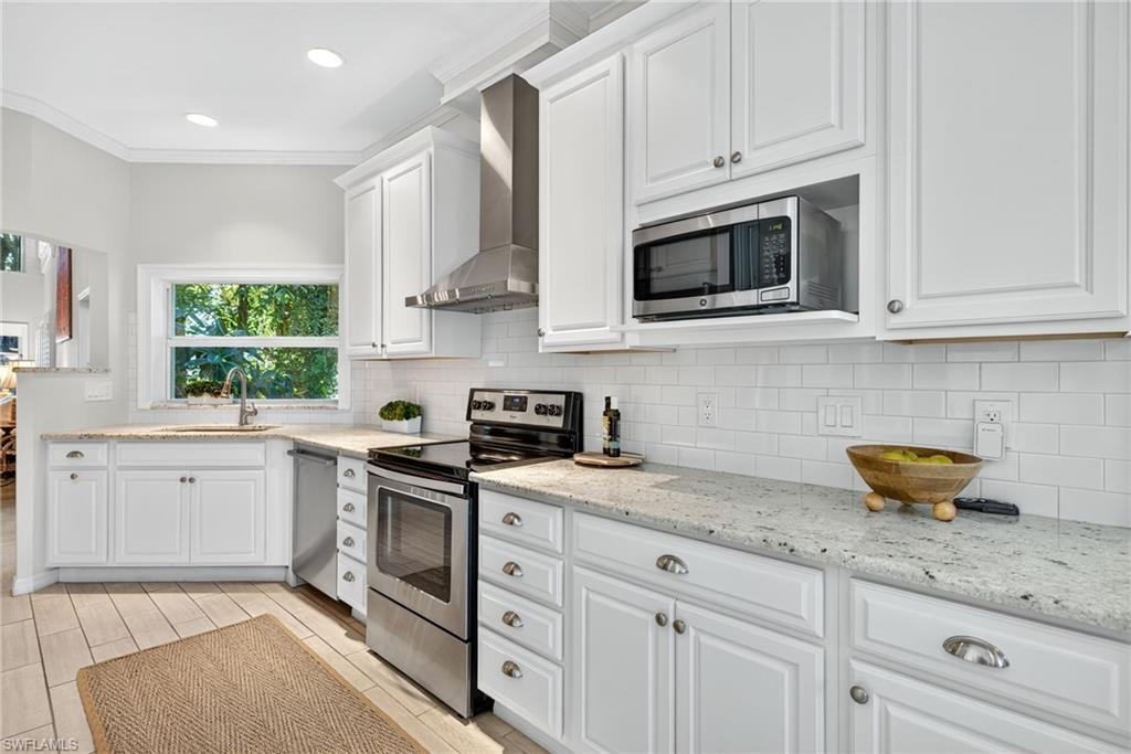 2193 Paget Circle, Unit 1 25 Naples, FL 34112 - Photo 13 of 50 a kitchen with stainless steel appliances granite countertop white cabinets a sink a stove and dishwasher