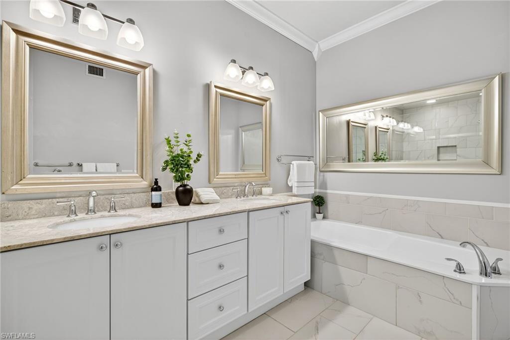 2193 Paget Circle, Unit 1 25 Naples, FL 34112 - Photo 20 of 50 a bathroom with a granite countertop sink mirror and bathtub