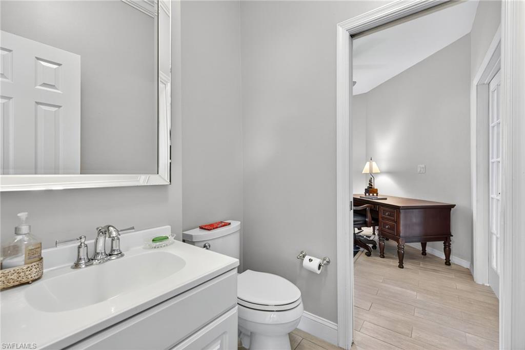 2193 Paget Circle, Unit 1 25 Naples, FL 34112 - Photo 27 of 50 a bathroom with a toilet sink vanity and mirror