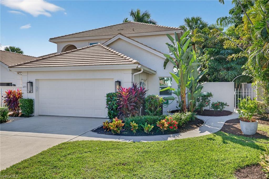 2193 Paget Circle, Unit 1 25 Naples, FL 34112 - Photo 32 of 50 a front view of a house with a yard and potted plants