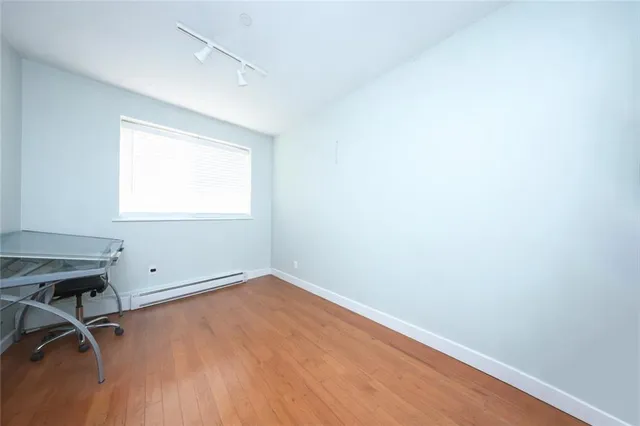 a view of a room with wooden floor and a window