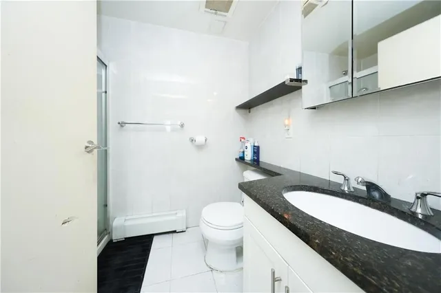 a bathroom with a granite countertop sink a toilet and a mirror