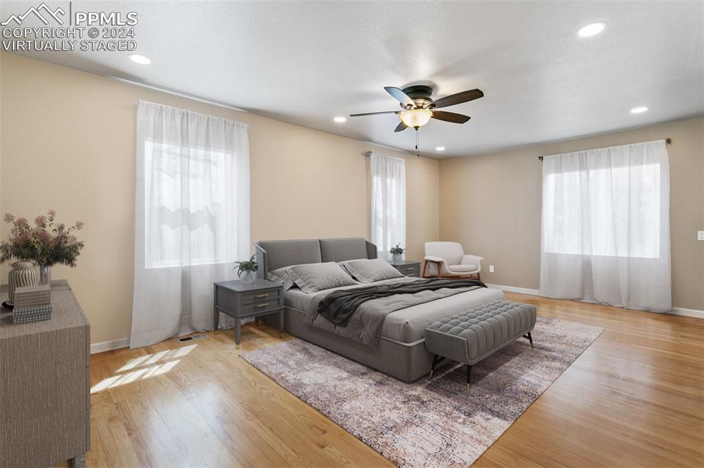 12990 Mc Cune Road Elbert, CO 80106 - Photo 22 of 50 a spacious bedroom with a bed and a chandelier