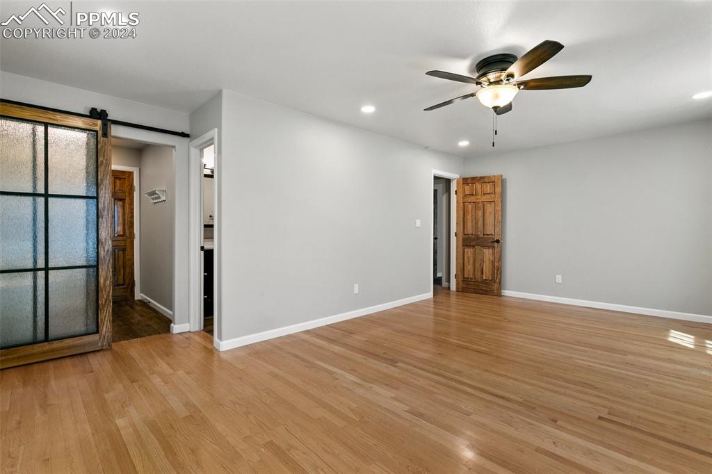 12990 Mc Cune Road Elbert, CO 80106 - Photo 24 of 50 an empty room with wooden floor chandelier fan and closet area