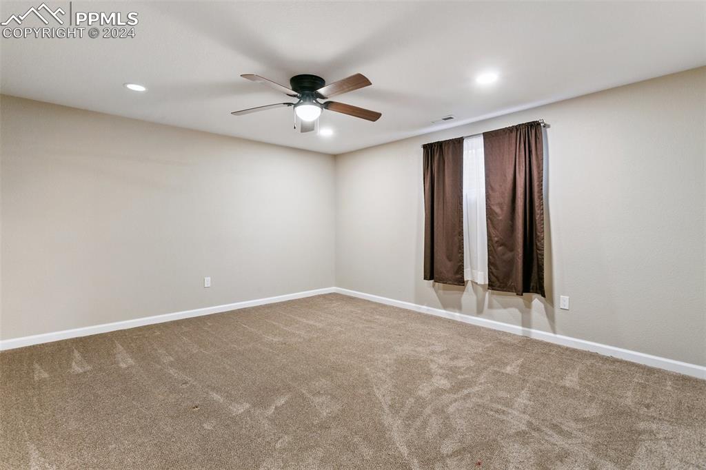 12990 Mc Cune Road Elbert, CO 80106 - Photo 34 of 50 an empty room with a ceiling fan and carpet