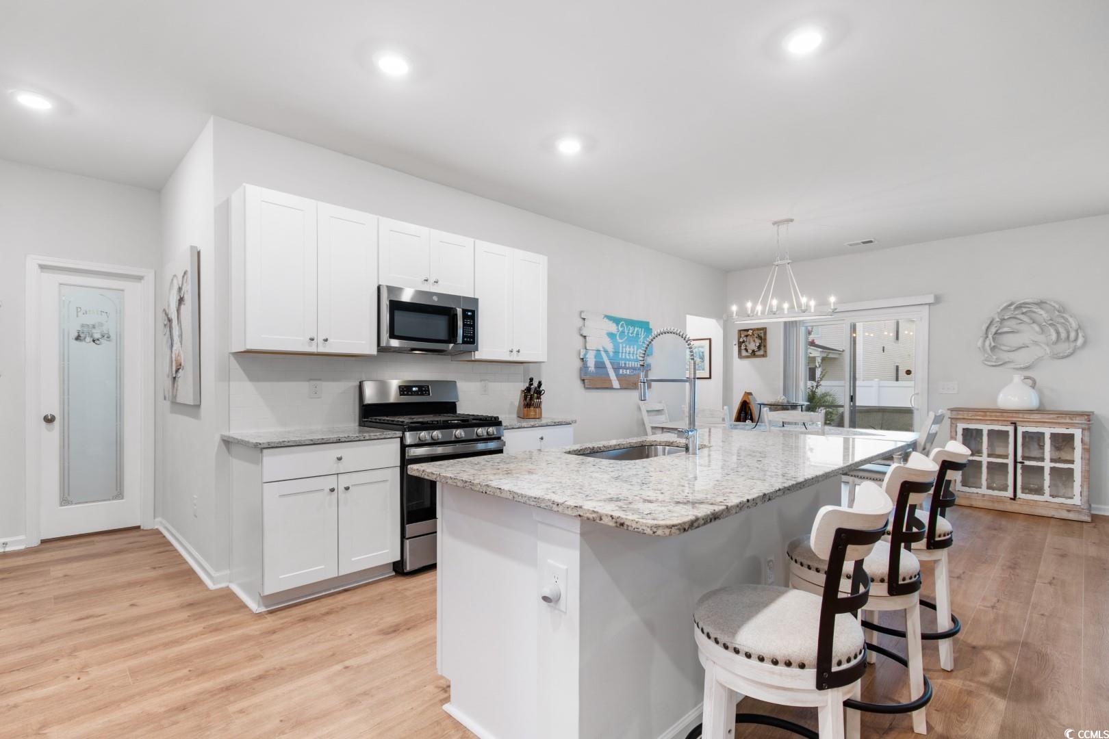 1075 Saltgrass Way Myrtle Beach, SC 29588 - Photo 5 of 40 Kitchen with white cabinets, hanging light fixture