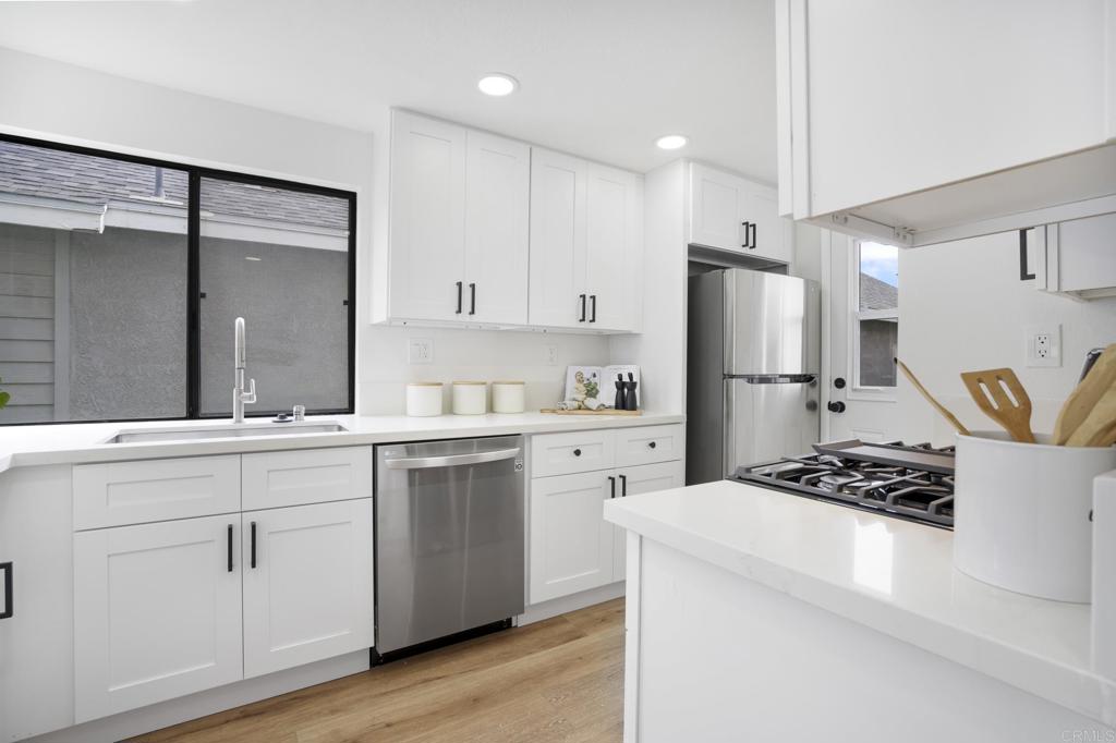 803 Skysail Avenue Carlsbad, CA 92011 - Photo 6 of 15 a kitchen with white cabinets and stainless steel appliances